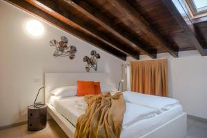 a bedroom with a white bed with a blanket on it at Iseo Vicolo Portelle - indoor private parking & bike storage in Iseo