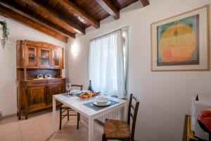 a dining room with a white table and chairs at Iseo Vicolo Portelle - indoor private parking & bike storage in Iseo