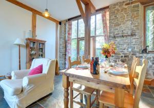 Llansawel的住宿－Threshing Barn，一间带木桌和椅子的用餐室
