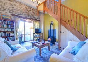 a living room with two white couches and a staircase at Pipistrelle in Llansawel