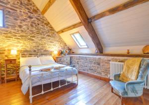 a bedroom with a bed and a stone wall at Pipistrelle in Llansawel