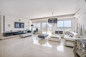 un ampio soggiorno con mobili bianchi e ampie finestre di Duplex Penthouse 3BR Asirey Tsyon By Holiday-rentals a Tel Aviv