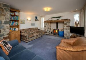a living room with a couch and a fireplace at Pelydryn in Abersoch