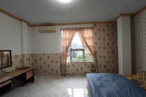 a bedroom with a bed and a window at Capital O 91650 Hotel Pratama in Kolaka