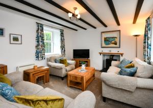 sala de estar con 2 sofás y chimenea en Pentraeth Cottage, en Abersoch