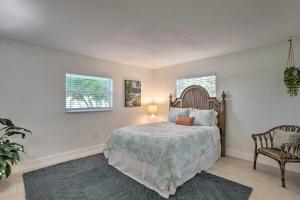 een slaapkamer met een bed en een stoel en 2 ramen bij Updated Family Beach Retreat Less Than 3 Mi to Ocean! in Jensen Beach