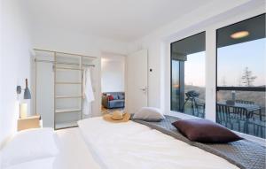 ein Schlafzimmer mit einem großen weißen Bett und einem Balkon in der Unterkunft Cozy Home In Lembruchdümmer See in Lembruch