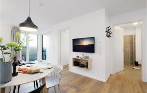 ein Esszimmer mit einem Tisch und einem TV an der Wand in der Unterkunft Cozy Home In Lembruchdümmer See in Lembruch