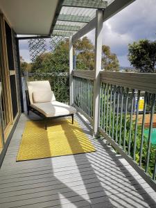 une terrasse couverte avec une chaise et un tapis jaune dans l'établissement Rare Find! 5-Bedroom Home with Pool and Pool Table, à Muswellbrook