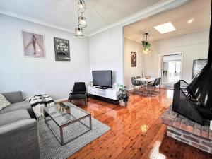 a living room with a couch and a table at Rare Find! 5-Bedroom Home with Pool and Pool Table in Muswellbrook