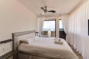 1 dormitorio con cama blanca y vistas al océano en Wonderfull duplex 3BR Hakovshim by Holiday-rentals, en Tel Aviv