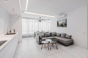 ein weißes Wohnzimmer mit einem Sofa und einem Tisch in der Unterkunft Beautifull 3BR in Masaryk by Holiday-rentals in Tel Aviv