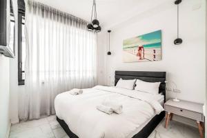 ein Schlafzimmer mit einem großen Bett mit zwei Handtüchern darauf in der Unterkunft Beautifull 3BR in Masaryk by Holiday-rentals in Tel Aviv