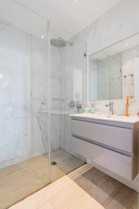 ein weißes Bad mit einem Waschbecken und einer Dusche in der Unterkunft Beautifull 3BR in Masaryk by Holiday-rentals in Tel Aviv