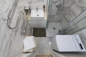 a white bathroom with a sink and a shower at RIVERFRONT 2BD Old Town Apartment by Hostlovers in Kaunas +23 photos