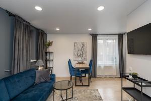 a living room with a blue couch and a table at RIVERFRONT 2BD Old Town Apartment by Hostlovers in Kaunas