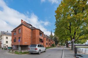 a car parked on a street next to a brick building at RIVERFRONT 2BD Old Town Apartment by Hostlovers in Kaunas