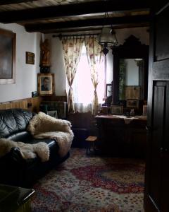a living room with a couch and a mirror at Sasfészek Pihenő in Kőszegszerdahely