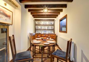 a dining room with a wooden table and chairs at Old Newton Cottage in Porthcawl