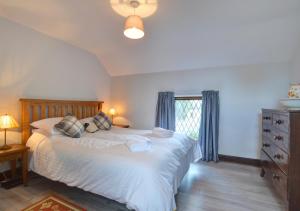 sypialnia z dużym łóżkiem i oknem w obiekcie Old Newton Cottage w mieście Porthcawl