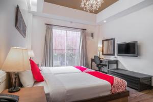 1 dormitorio con cama, escritorio y ventana en OYO 579 Anisabel Suites, en Davao City