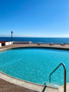 una piscina con l'oceano sullo sfondo di MODERN SPACIOUS BEACH FRONT CENTRAL CONDO w POOLS STEPS TO BEACH a Rosarito