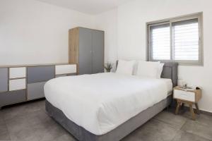 Un pat sau paturi într-o cameră la Central 3BR in Ruppin by Holiday-rentals