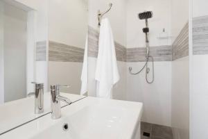 a white bathroom with a sink and a shower at Central 3BR in Ruppin by Holiday-rentals in Tel Aviv