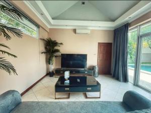 - un salon avec un canapé et une télévision dans l'établissement Pool villas with big garden and near Jomtien beach 600 meters, à Jomtien Beach
