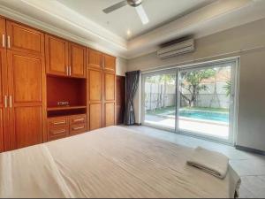 - une chambre avec un grand lit et une grande fenêtre dans l'établissement Pool villas with big garden and near Jomtien beach 600 meters, à Jomtien Beach