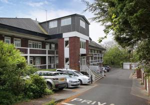 un edificio con coches estacionados en un estacionamiento en Woodridge Court, en Newton