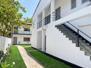 an external view of a house with stairs and grass at The Anchorage Holiday Apartments - Negombo in Negombo