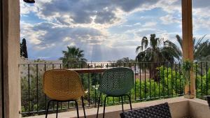 Duas cadeiras numa varanda com vista para o oceano em Bar suite em Ein Gedi