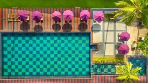 an overhead view of a swimming pool with purple umbrellas at Avani Bentota Resort in Bentota