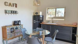 a kitchen with a glass table and blue chairs at Bar suite in Ein Gedi