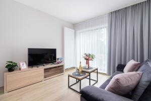 a living room with a couch and a flat screen tv at Modern Apartments Śródmiescie Kraków by Renters in Krakow