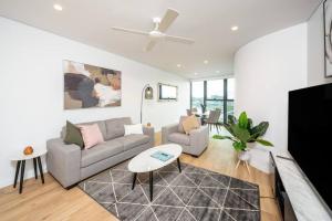 a living room with a couch and a table at 1404 Sophistication and Luxury on the Brisbane River by Stylish Stays in Brisbane
