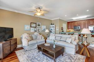 a living room with a couch and a table at Carrabelle Condo Beach and Fishing Pier Access in Big Blackjack Landing