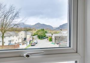 a window with a view of a street and mountains at Ty Manod in Blaenau-Ffestiniog