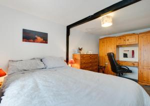 1 dormitorio con 1 cama grande y 1 silla negra en Ty Manod en Blaenau-Ffestiniog