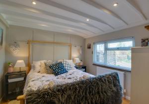 Un dormitorio con una cama grande y una ventana en The Cabin at Bragdy, en Dinas