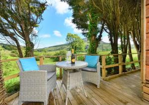 un patio con mesa y sillas en una terraza en The Cabin at Bragdy, en Dinas