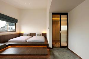 a bedroom with a bed and a large window at Beanstalk Bangkok in Bangkok