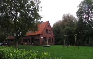 ein Haus mit einem Spielplatz davor in der Unterkunft Ferienwohnung Lüken in Hooksiel