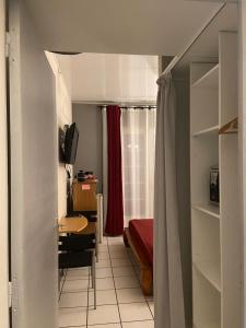 Zimmer mit einem Schreibtisch und einem Schlafzimmer. in der Unterkunft Happyhome in Saint-Pierre