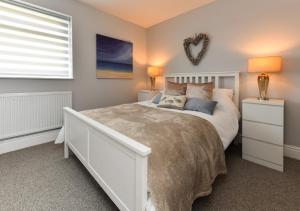 a bedroom with a large white bed and a window at Sealight in Pwllheli