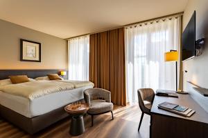 um quarto de hotel com uma cama, uma cadeira e uma secretária em Art Boutique Hotel Monopol em St. Moritz