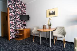 Zimmer mit einem Tisch, 2 Stühlen und einem TV in der Unterkunft Hotel SANVIT RESTAURACJA & SPA in Sanok