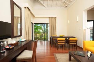 a living room with a table and yellow chairs at Club Hotel Dolphin in Negombo