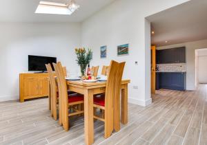 Llanfynydd的住宿－Tyisaf，一间带木桌和椅子的用餐室